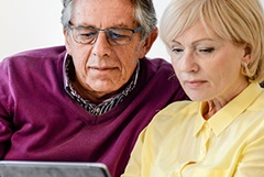 Seniorenpaar informiert sich online, was Osteoporose ist